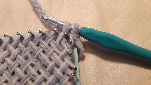 Yarn pulled through first corner loop